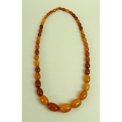 885 - A butterscotch amber necklace of graduated beads, the largest measuring 30mm by 20mm, 90.2g.