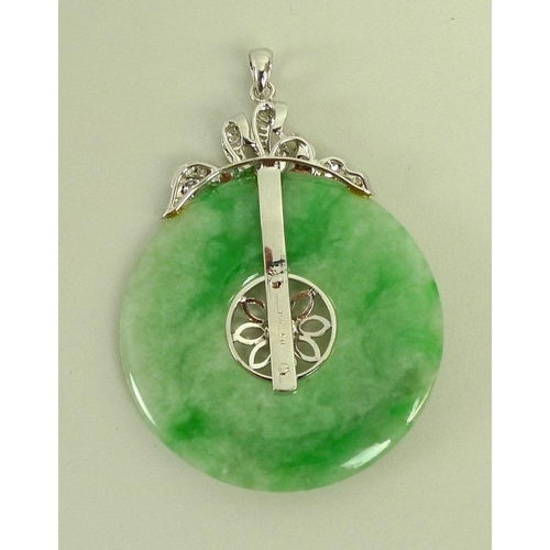 888 - A jade and diamond pendant, the carved jade disc set centrally with floral design and brilliant cut ... 