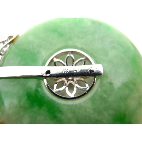 888 - A jade and diamond pendant, the carved jade disc set centrally with floral design and brilliant cut ... 