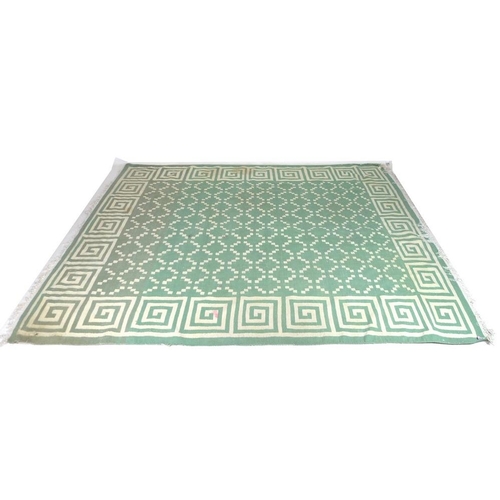 896 - A flat weave Dhurrie rug, with a green ground and geometric pattern, 350 by 280cm.