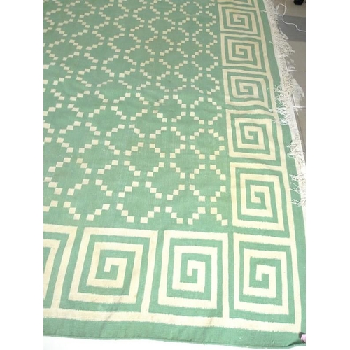 896 - A flat weave Dhurrie rug, with a green ground and geometric pattern, 350 by 280cm.