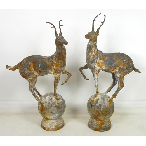 901 - A pair of cast iron garden statues, late 20th century, modelled as a stags, each standing upon a sph... 