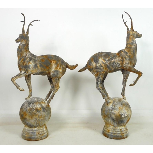 901 - A pair of cast iron garden statues, late 20th century, modelled as a stags, each standing upon a sph... 