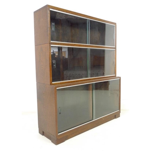 916 - A late 1930's Minty Ltd three section bookcase, with sliding glass doors and steel insets, with labe... 