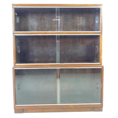 916 - A late 1930's Minty Ltd three section bookcase, with sliding glass doors and steel insets, with labe... 