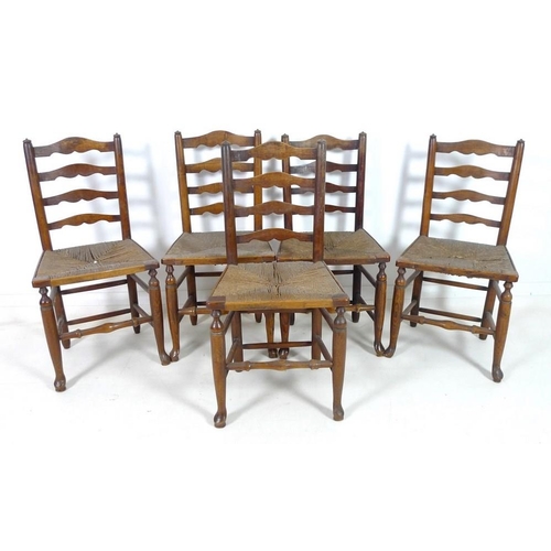 917 - A set of five 19th century oak country ladderback chairs, with rush seats, turned supports joined by... 