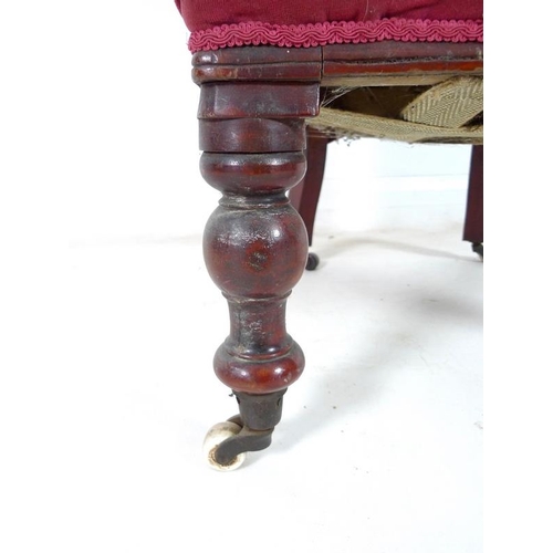 936 - A Victorian mahogany nursing chair, moulded frame, turned front legs and castors, upholstered in but... 