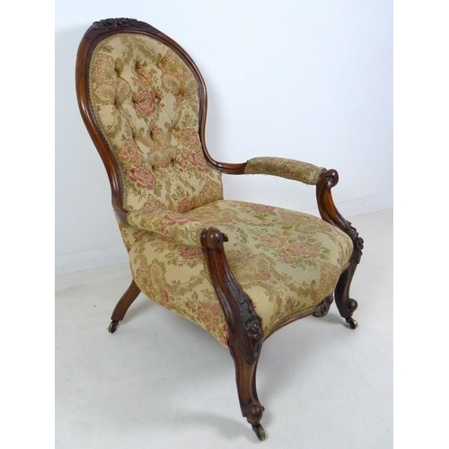 950 - A Victorian nursing chair, the walnut frame carved with roses and scrolls, upholstered in button bac... 