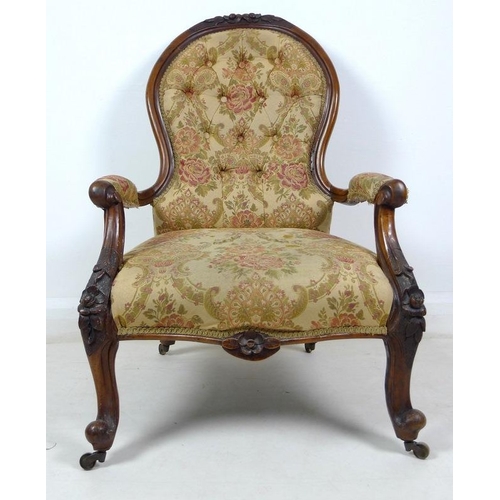 950 - A Victorian nursing chair, the walnut frame carved with roses and scrolls, upholstered in button bac... 