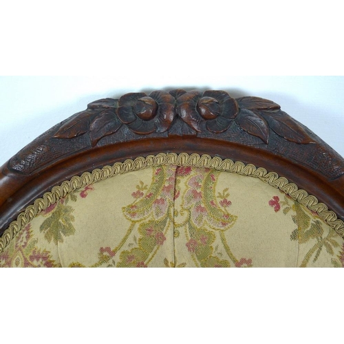 950 - A Victorian nursing chair, the walnut frame carved with roses and scrolls, upholstered in button bac... 