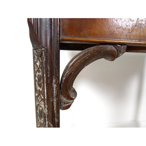 954 - A 19th century mahogany carved table, shaped fold over surface over a plain frieze, raised on chamfe... 