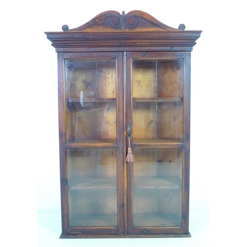 955 - A Victorian style stained pine glazed bookcase, mid 20th century, two glazed doors enclosing three f... 