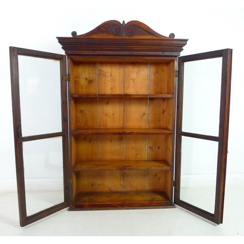 955 - A Victorian style stained pine glazed bookcase, mid 20th century, two glazed doors enclosing three f... 