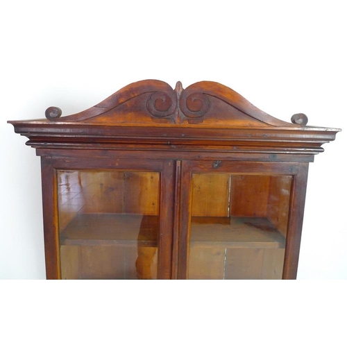 955 - A Victorian style stained pine glazed bookcase, mid 20th century, two glazed doors enclosing three f... 