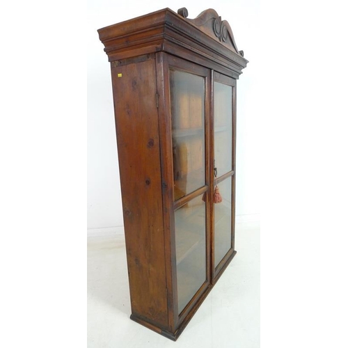 955 - A Victorian style stained pine glazed bookcase, mid 20th century, two glazed doors enclosing three f... 