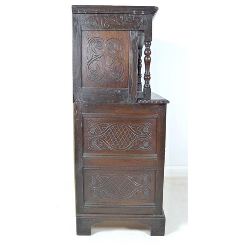 957 - A 17th century narrow court cupboard of conventional form, carved overall with scrolls and geometric... 