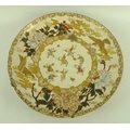 A Japanese Satsuma pottery charger, the central circular panel painted with children at play and sur... 