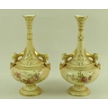 A pair of Royal Worcester blush ivory bottle vases, circa 1894, the handles modelled with rams head ... 
