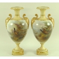 A pair of Royal Worcester blush ivory vases of tapered urn form, with moulded handles, the bodies pa... 