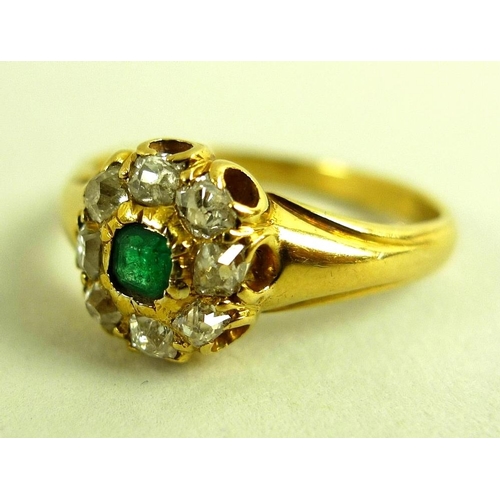 788 - A 1950's 18ct gold, diamond and emerald dress ring of stylised setting, with central emerald cut eme... 