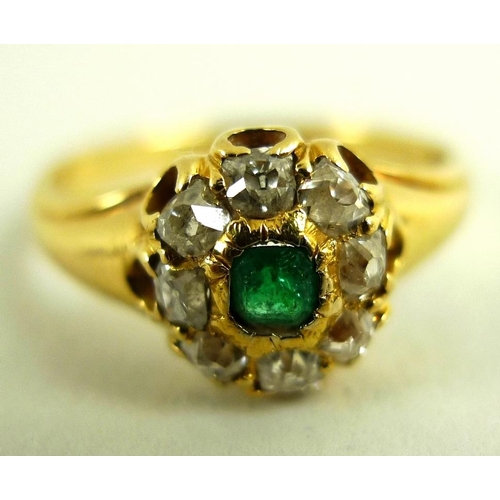 788 - A 1950's 18ct gold, diamond and emerald dress ring of stylised setting, with central emerald cut eme... 