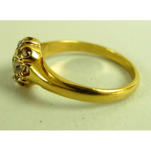 788 - A 1950's 18ct gold, diamond and emerald dress ring of stylised setting, with central emerald cut eme... 