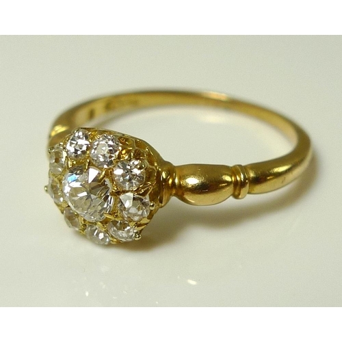 828 - An 18ct gold and diamond cluster ring, the central stone of approximately 0.25ct, surrounded by nine... 