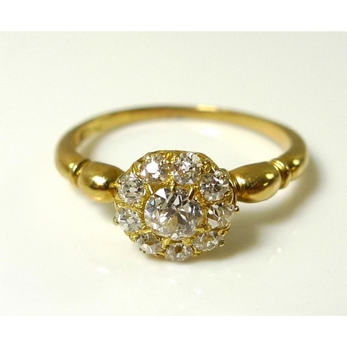 828 - An 18ct gold and diamond cluster ring, the central stone of approximately 0.25ct, surrounded by nine... 