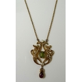 An Art Nouveau 15ct gold, peridot, ruby and seed pearl pendant of scrolled lyre form, in the suffrag... 