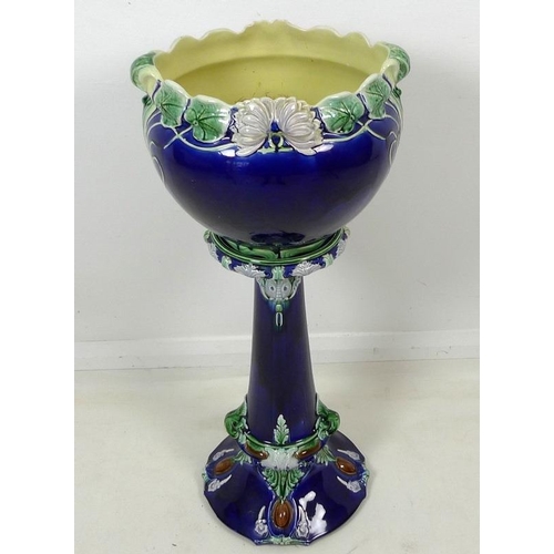 842 - An Art Nouveau Majolica jardiniere and stand, the cobalt blue ground decorated with lilies and leave... 