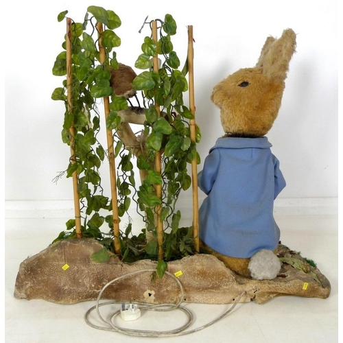 855 - A large automaton of Peter Rabbit in Mr McGregor's garden, mid to late 20th century, 95 by 36 by 77c... 