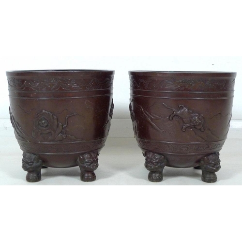 857 - A pair of Japanese bronze jardinieres, circa 1910, decorated in relief with tigers in a rocky mounta... 