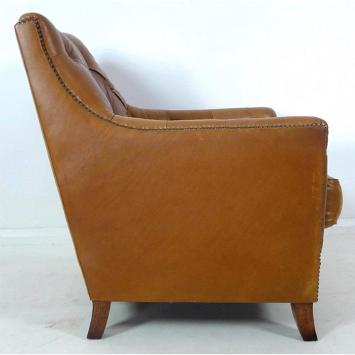 860 - A pair of brown leather button back arm chairs, late 20th century, raised on sabre legs, 75 by 89 by... 