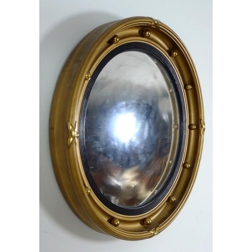 863 - An early 20th century gilt framed circular bull's eye mirror, the frame set with orbs, reeded and ri... 