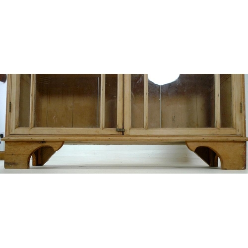 863A - A Victorian pine glazed bookcase, twin glazed doors with brass knob, three fixed shelves, raised on ... 