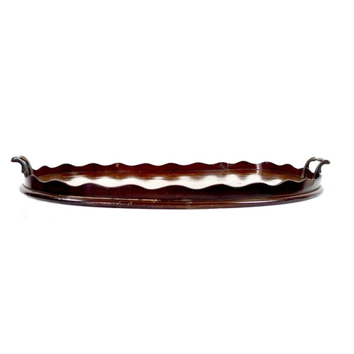 864A - A Edwardian mahogany kidney shaped tray, with central inlaid decoration of flowers and musical instr... 