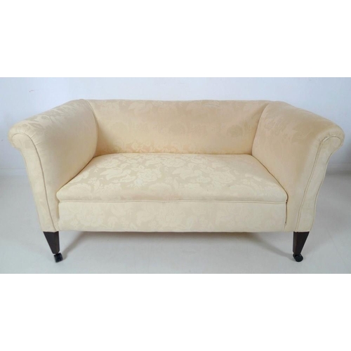 873 - An Edwardian drop end two seater settee, upholstered in cream foliate fabric, raised on square secti... 