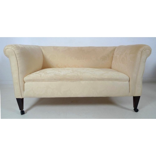 873 - An Edwardian drop end two seater settee, upholstered in cream foliate fabric, raised on square secti... 