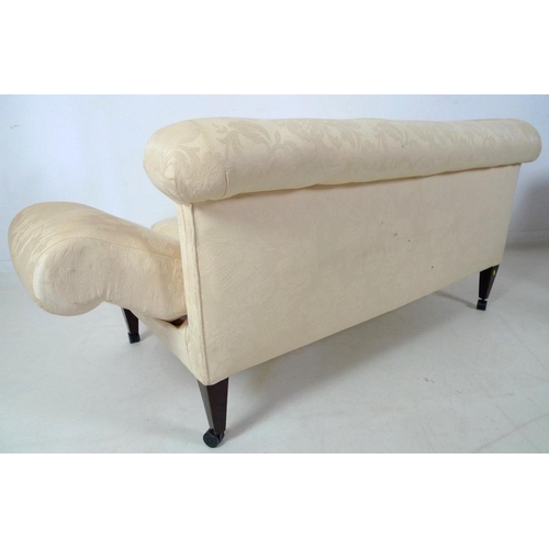 873 - An Edwardian drop end two seater settee, upholstered in cream foliate fabric, raised on square secti... 