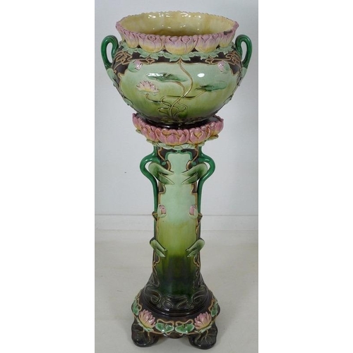 878 - An Austrian Art Nouveau ceramic jardiniere and stand, modelled overall with water lily flowers and l... 