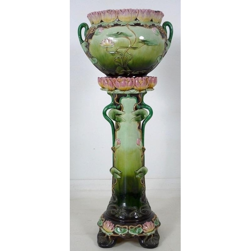 878 - An Austrian Art Nouveau ceramic jardiniere and stand, modelled overall with water lily flowers and l... 