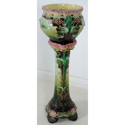 878 - An Austrian Art Nouveau ceramic jardiniere and stand, modelled overall with water lily flowers and l... 