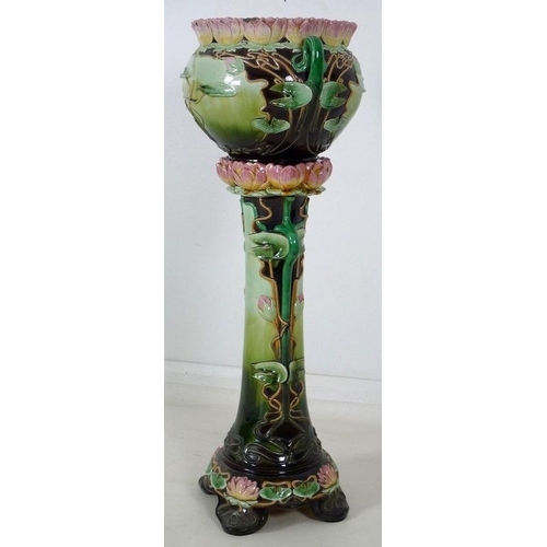 878 - An Austrian Art Nouveau ceramic jardiniere and stand, modelled overall with water lily flowers and l... 