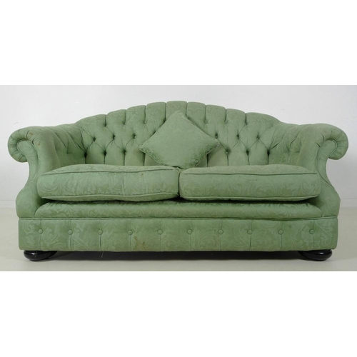 882 - A Victorian style two seater settee, with arched button back, scroll arms and flattened bun feet, up... 