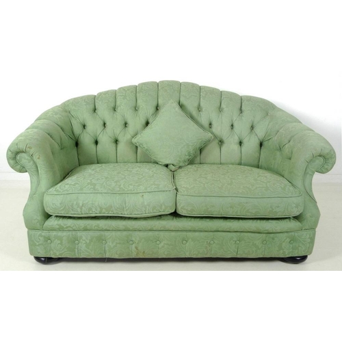 882 - A Victorian style two seater settee, with arched button back, scroll arms and flattened bun feet, up... 