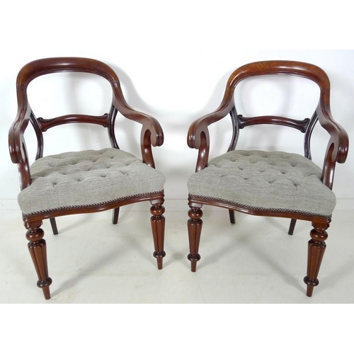 884 - A pair of 19th century open armed library chairs, by Gillows, shaped backs with scroll arms, the sea... 