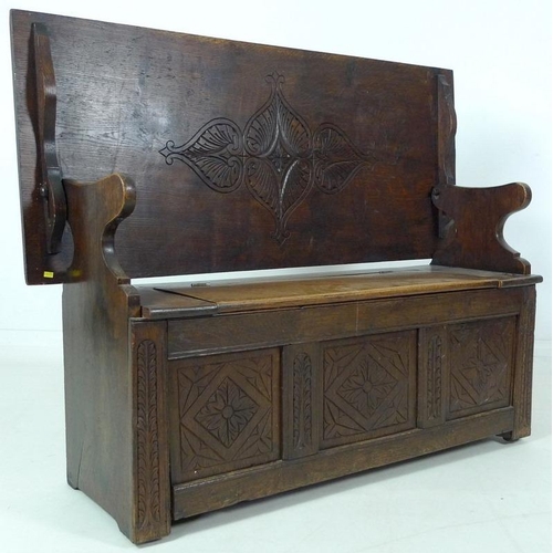 888 - A Victorian oak monk's bench, three panel front carved with floral and foliate motif, lift lid seat,... 