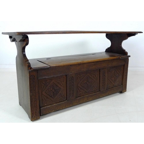 888 - A Victorian oak monk's bench, three panel front carved with floral and foliate motif, lift lid seat,... 