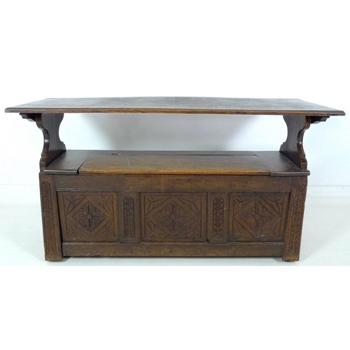 888 - A Victorian oak monk's bench, three panel front carved with floral and foliate motif, lift lid seat,... 