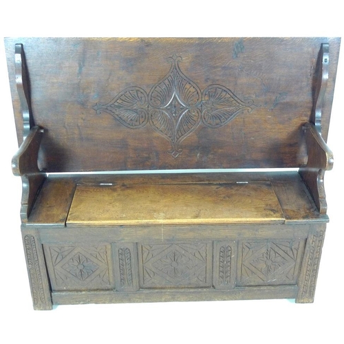 888 - A Victorian oak monk's bench, three panel front carved with floral and foliate motif, lift lid seat,... 